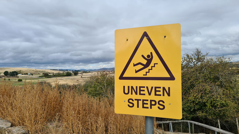 A sign warning people about uneven steps