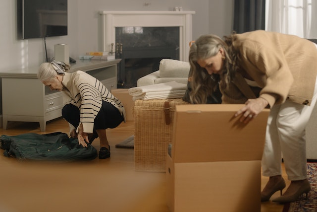 Two elderly women decluttering a home.