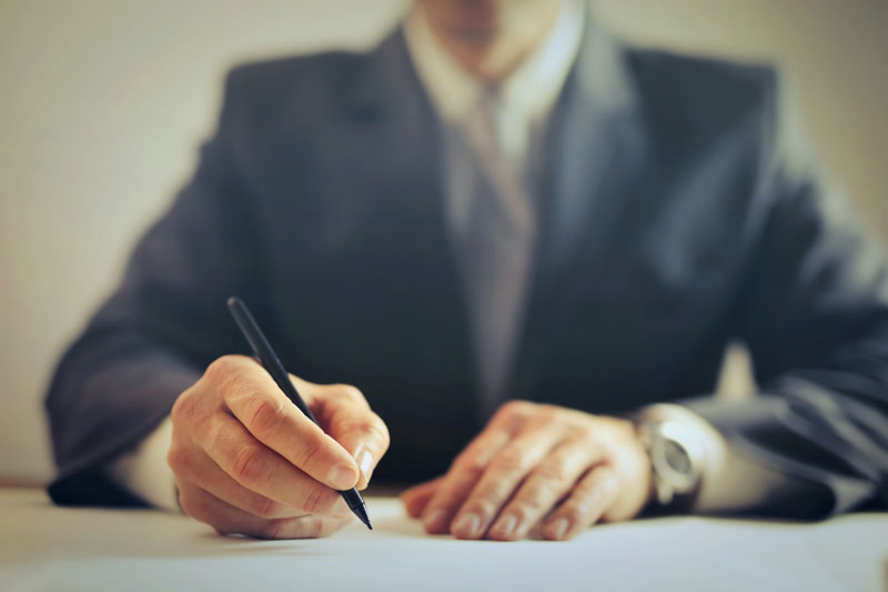 A man writing on a paper.