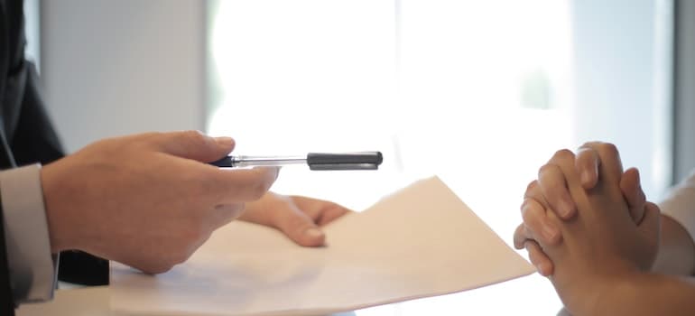 a man considering whether to sign a document or not